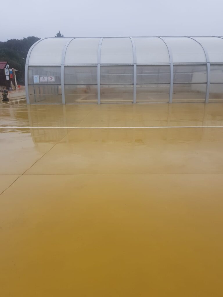 Plage de piscine en béton lissé teinte ocre