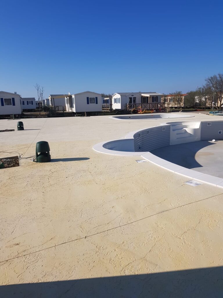 Plage de piscine en béton décoratif finition claire